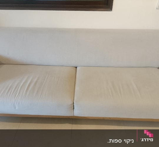 ספה בהירה עם כריות על רצפת אריחים